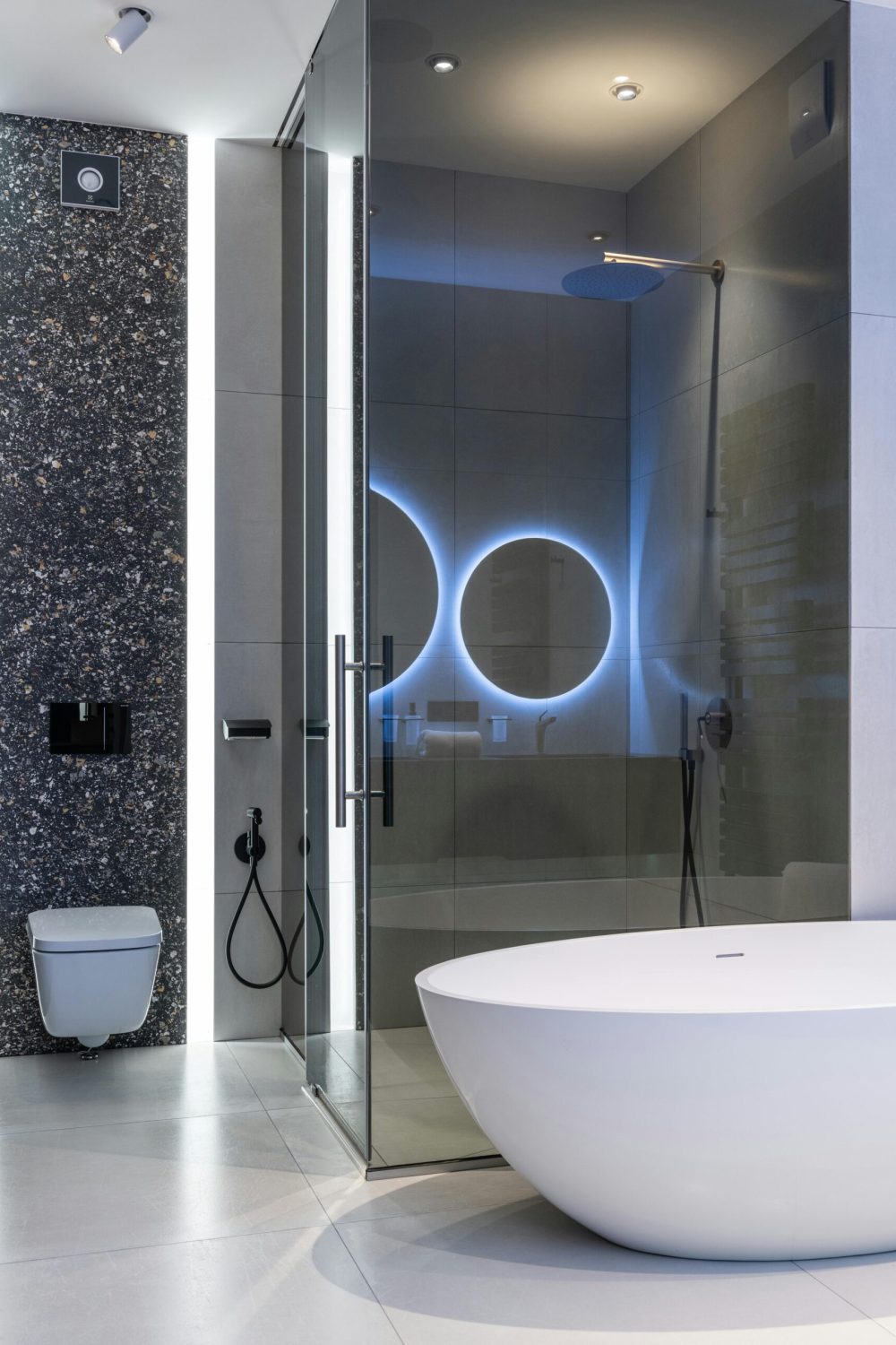 Sleek modern bathroom featuring a freestanding tub and illuminated shower area.